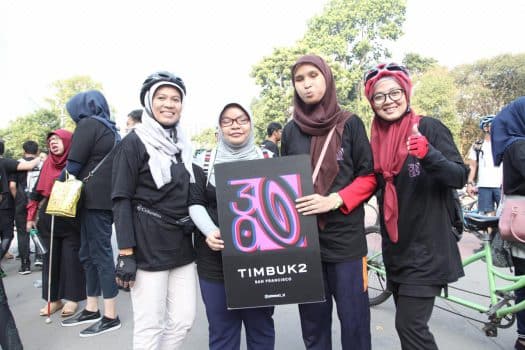 Beberapa orang memegang banner logo 30 tahun Timbuk 2
